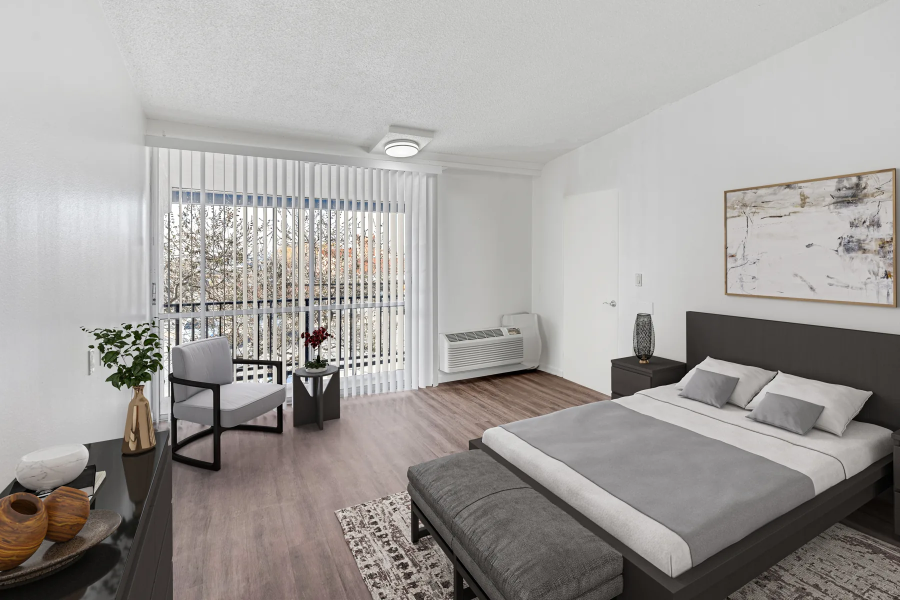 Furnished bedroom with wood-style flooring and large window at ABQ Encore Apartments