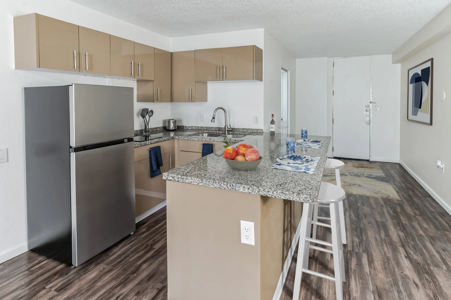 Renovated kitchen with granite breakfast bar and stainless steel appliances at ABQ Encore Apartments